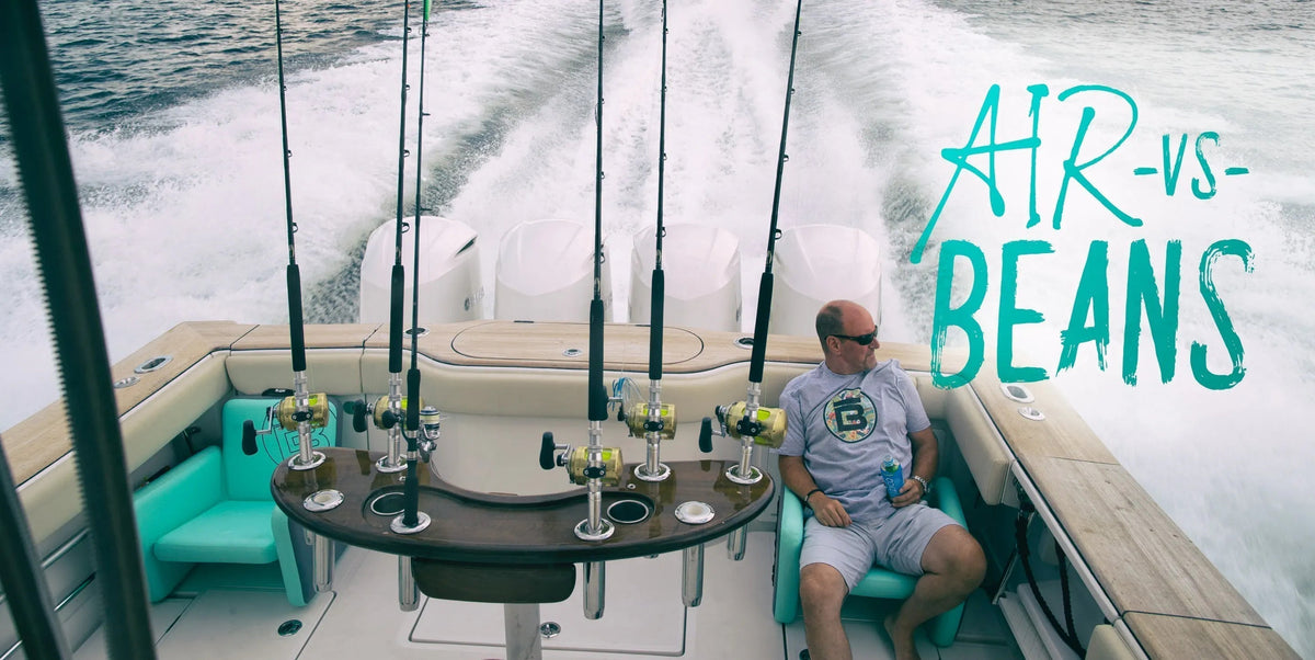 Man sitting on the back of a boat enjoying a drink sitting on an inflatable BOTE chair with multiple fishing rods stacked up ready to go.