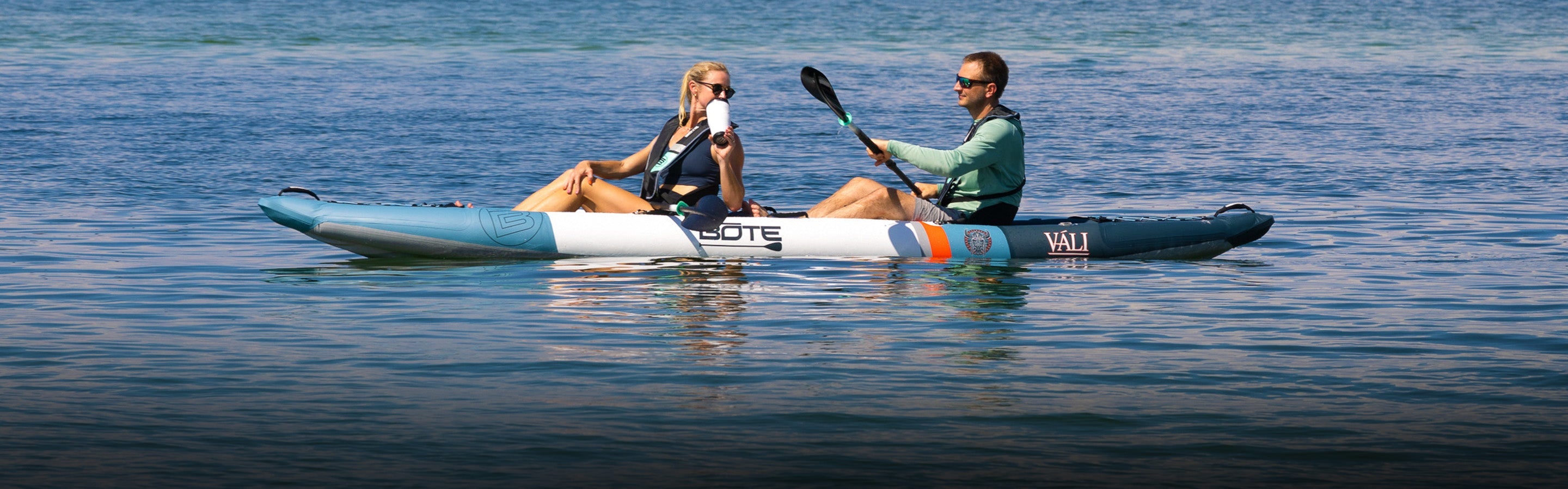 Two people in a tandem kayak on calm water