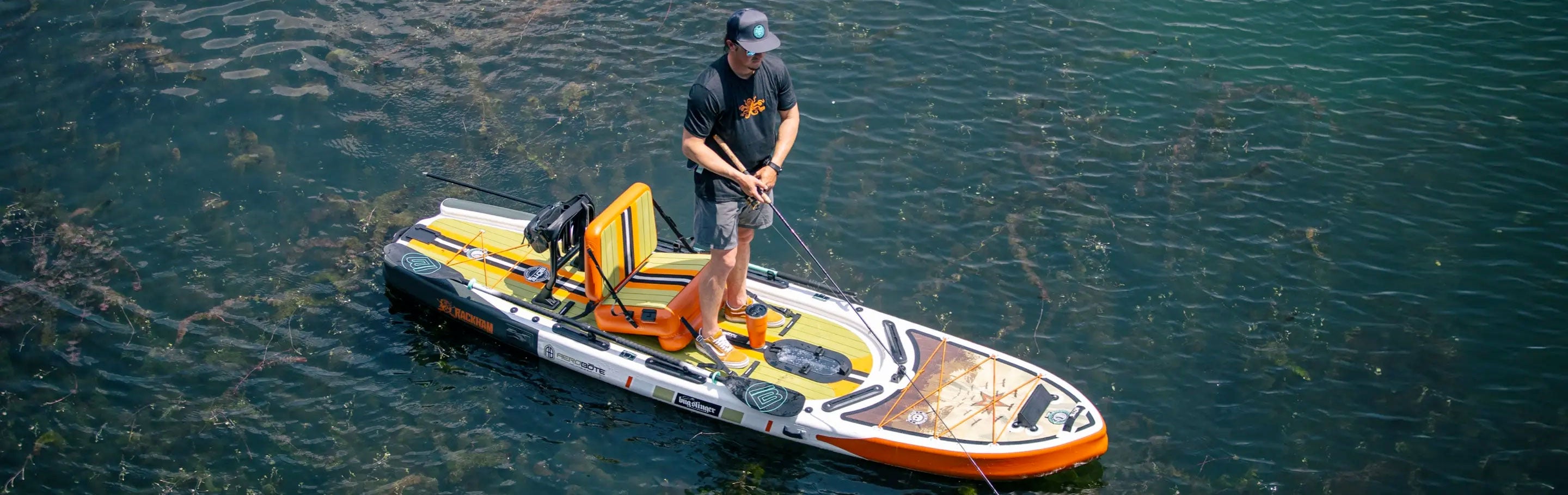 Man fishing from orange inflatable paddle board equipped with pedal drive system.