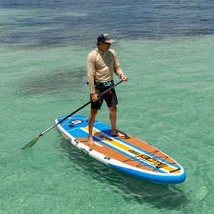Man stand-up paddleboarding on a LowRider Aero Tandem in clear water.