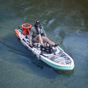 Angled view of ProRider Aero paddle board with pedal drive and cooler on calm water.