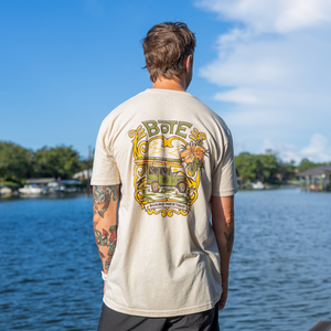 Back view of a guy wearing a BOTE Board Meeting Tee while looking out over the water