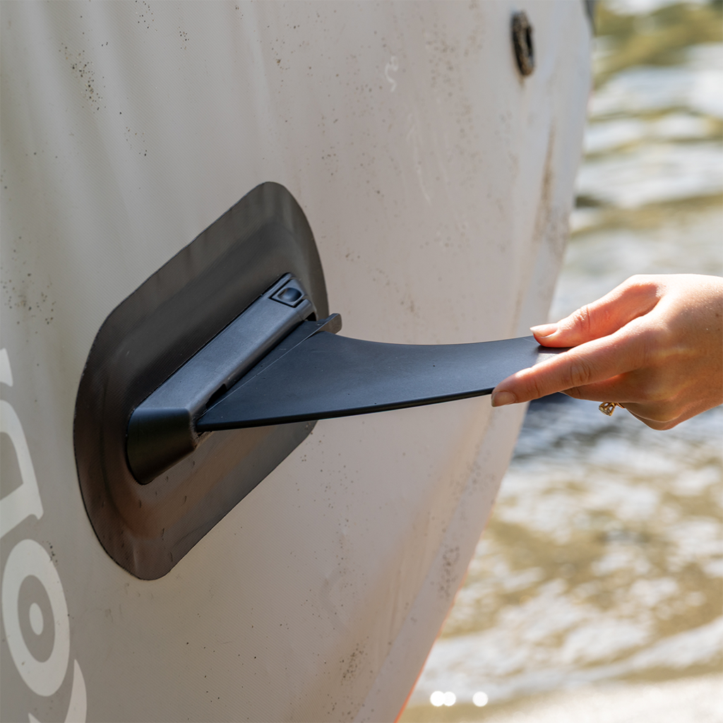 Hand inserting 6" Click-In Center Fin into a fin box on a paddle board.