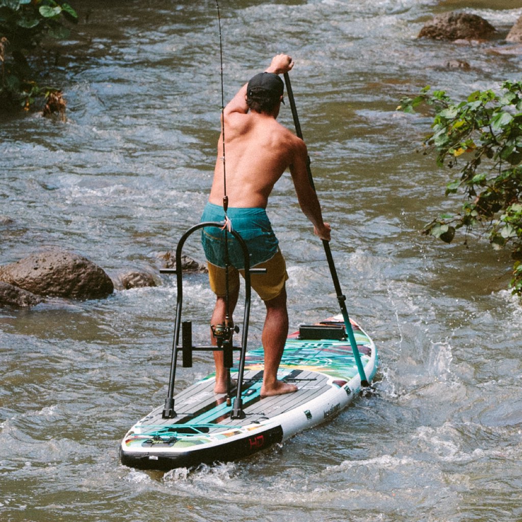 Lifestyle image of Tackle Rac Black on paddle board as man paddles through a river.