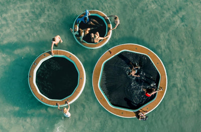 Top view of people relaxing and swimming around Hangout Water Hammocks.