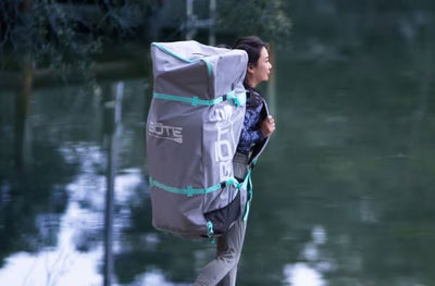 Woman carrying packed EasyRider Aero in a large gray travel bag.
