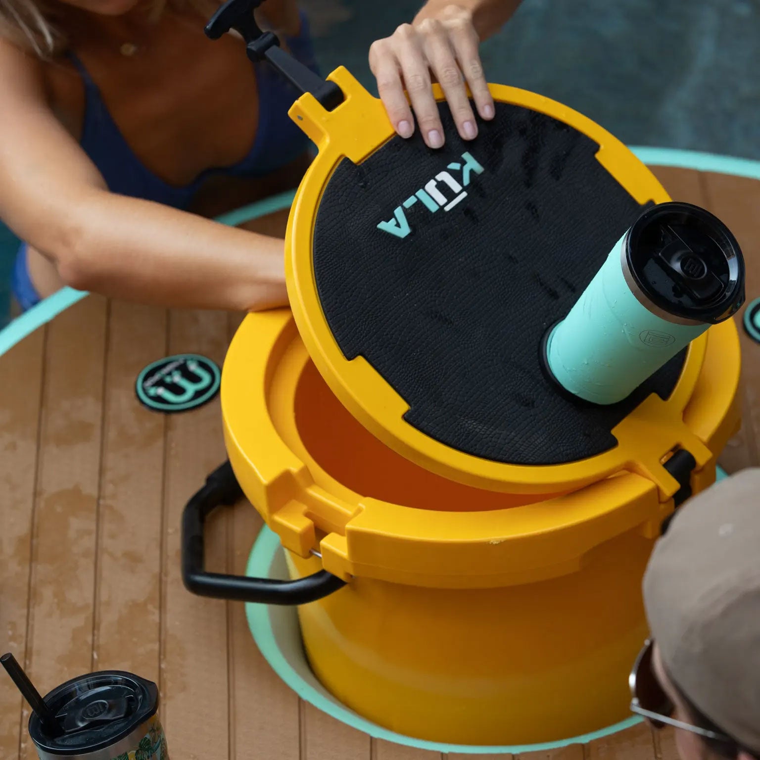Top view of aqua MAGNEPOD tumbler attached to a yellow KULA cooler lid.