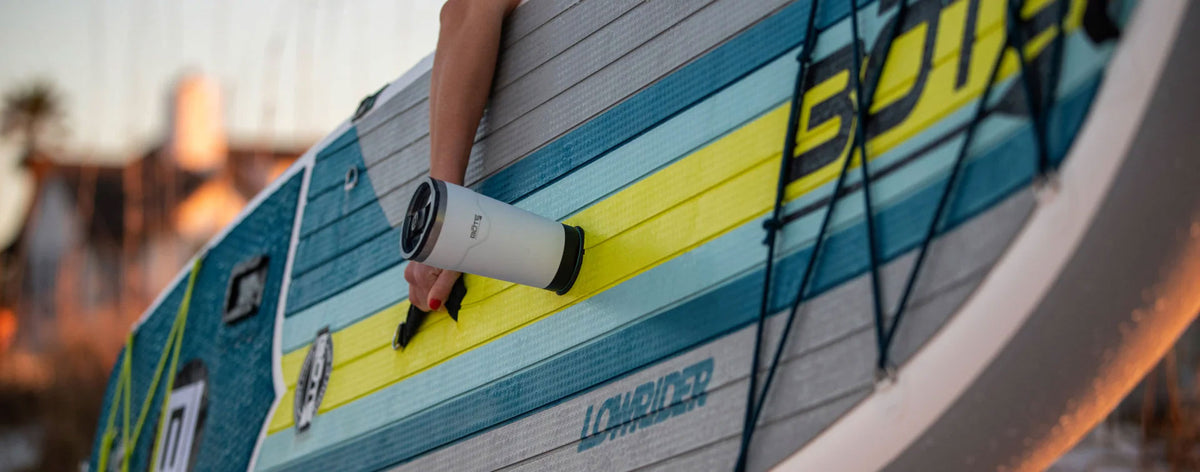 Angled view of white MAGNEPOD bottle secured to a paddle board deck.