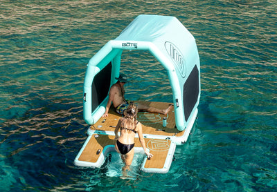 Inflatable Canopy attached to an inflatable floating platform with 2 people on a body of water.