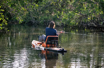 Person seated on the Rackham Gatorshell APEX in kayak mode, fishing on calm water.