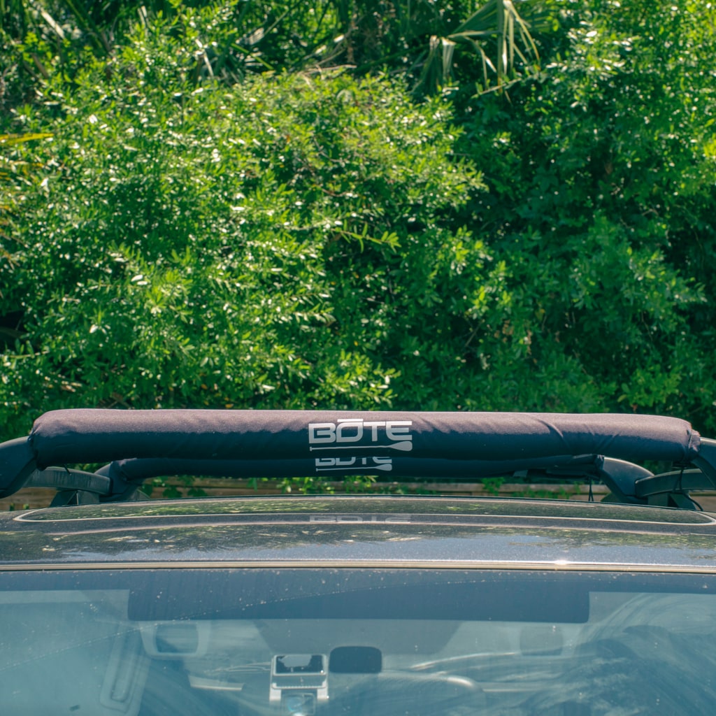 Black roof rack pads on pre-installed roof racks on the top of a vehicle